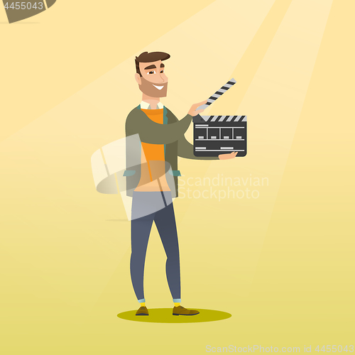 Image of Smiling man holding an open clapperboard.