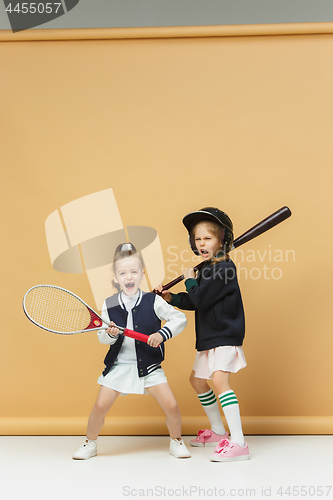 Image of Portrait of two girls as tennis players holding tennis racket. Studio shot.