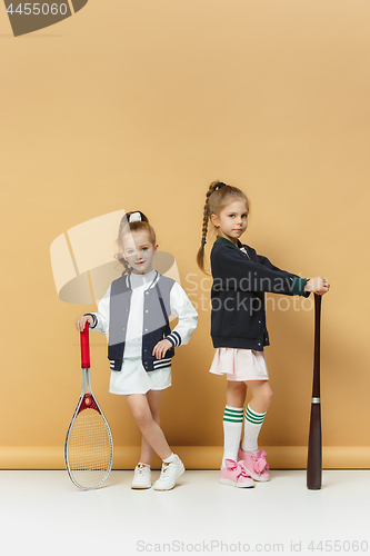 Image of Portrait of two girls as tennis players holding tennis racket. Studio shot.