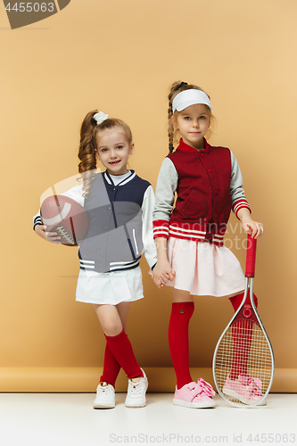Image of Two happy and beautyful children show different sport. Studio fashion concept. Emotions concept.