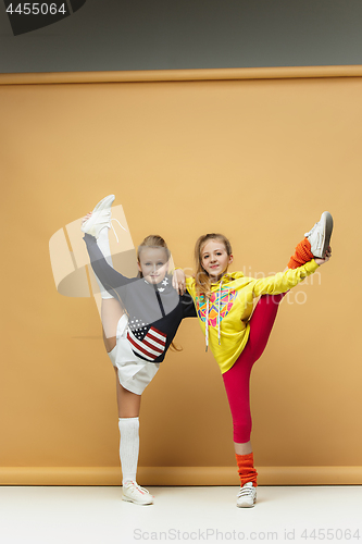 Image of Two happy children show different sport. Studio fashion concept. Emotions concept.