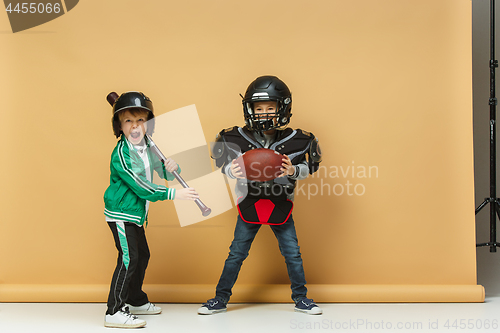 Image of Two happy children show different sport. Studio fashion concept. Emotions concept.