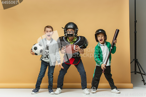 Image of Three happy children show different sport. Studio fashion concept. Emotions concept.