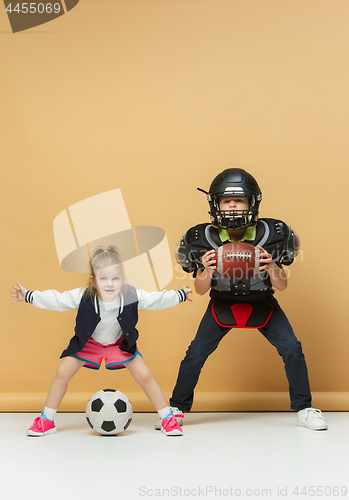 Image of Two happy and beautyful children show different sport. Studio fashion concept. Emotions concept.