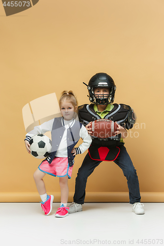 Image of Two happy and beautyful children show different sport. Studio fashion concept. Emotions concept.