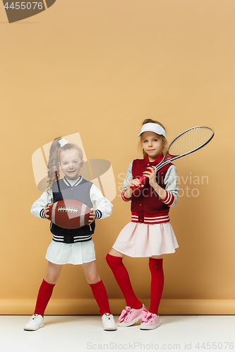 Image of Two happy and beautyful children show different sport. Studio fashion concept. Emotions concept.