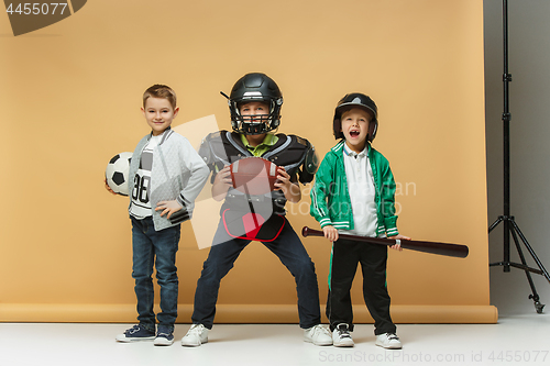 Image of Three happy children show different sport. Studio fashion concept. Emotions concept.