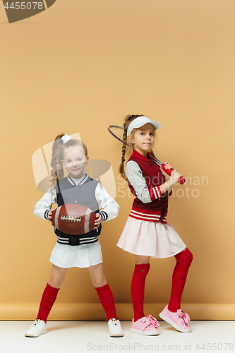 Image of Two happy and beautyful children show different sport. Studio fashion concept. Emotions concept.