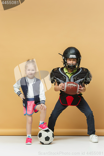 Image of Two happy and beautyful children show different sport. Studio fashion concept. Emotions concept.