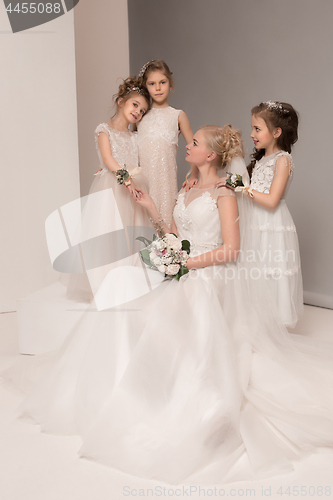 Image of Little pretty girls with flowers dressed in wedding dresses