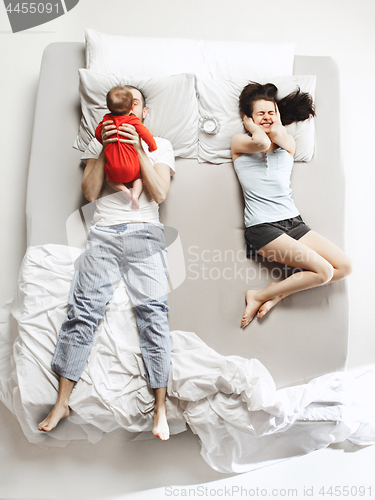 Image of Top view of happy family with one newborn child in bedroom.