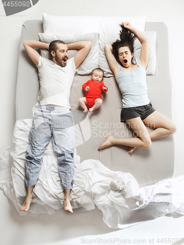 Image of Top view of happy family with one newborn child in bedroom.