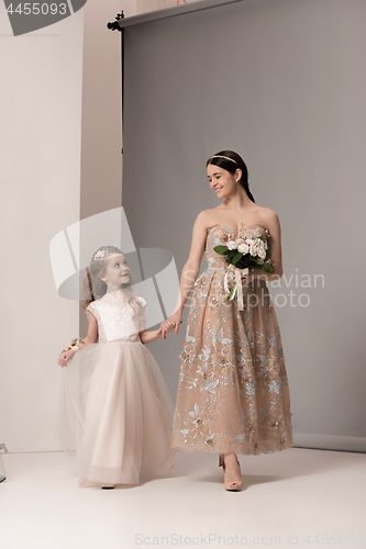 Image of Little pretty girls with flowers dressed in wedding dresses