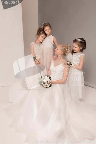 Image of Little pretty girls with flowers dressed in wedding dresses