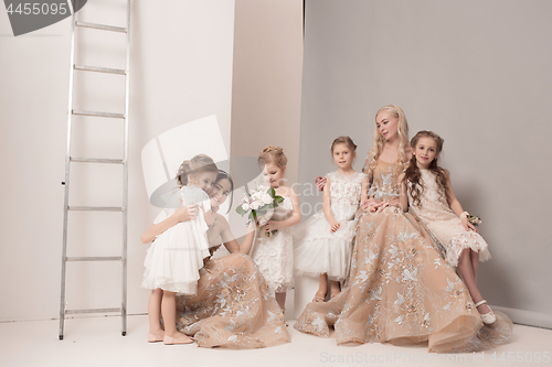 Image of Little pretty girls with flowers dressed in wedding dresses