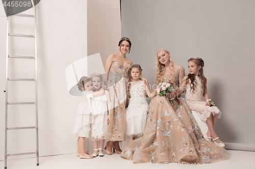 Image of Little pretty girls with flowers dressed in wedding dresses