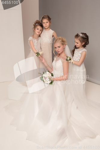 Image of Little pretty girls with flowers dressed in wedding dresses