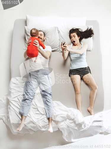 Image of Top view of happy family with one newborn child in bedroom.