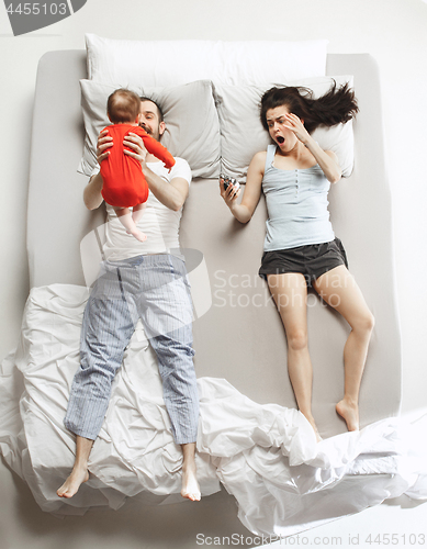 Image of Top view of happy family with one newborn child in bedroom.