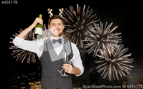 Image of man with bottle of champagne at christmas party