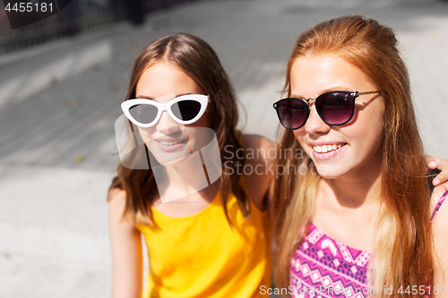 Image of smiling teenage girls in sunglasses outdoors
