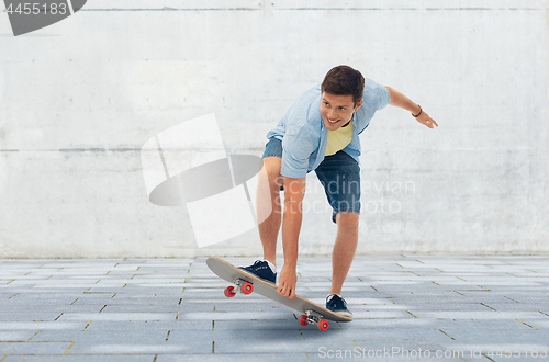 Image of young man riding skateboard over urban background