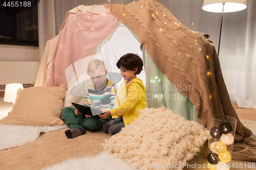 Image of little boys with tablet pc in kids tent at home