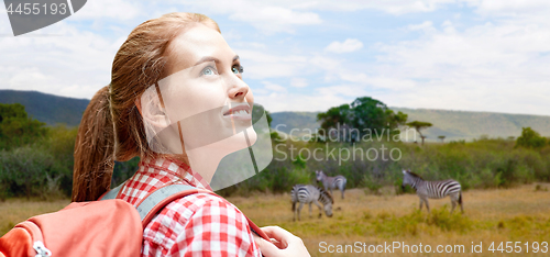 Image of happy woman with backpack over african savannah