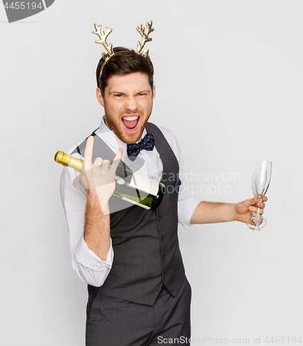 Image of man with bottle of champagne at christmas party