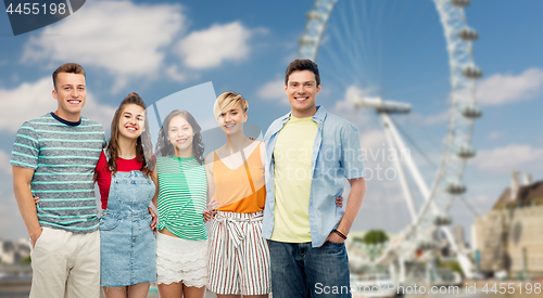 Image of happy friends hugging over ferry wheel in london