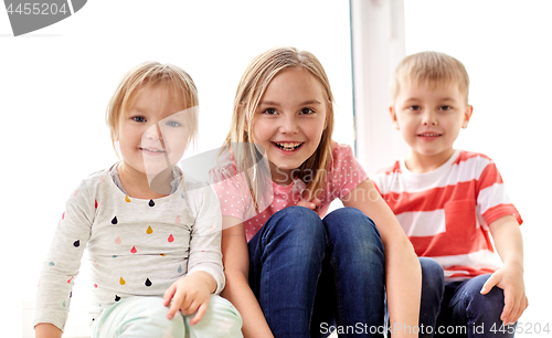 Image of happy little kids having fun at window