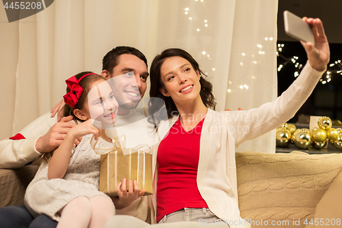 Image of happy family with christmas present at home