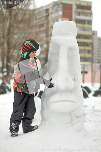 Image of Boy making a winter snowman