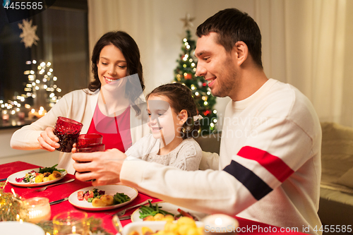 Image of happy family having christmas dinner at home