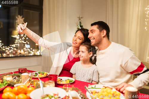 Image of happy family taking selfie at christmas dinner