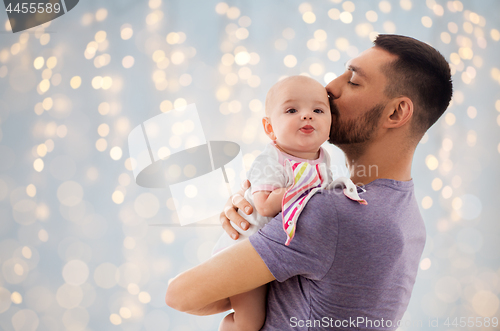 Image of father kissing little baby daughter