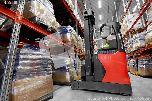 Image of male loader operating forklift at warehouse