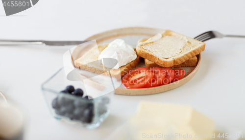 Image of toasts with poached egg and vegetables on plate