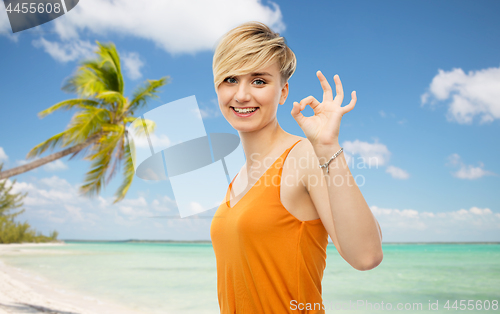 Image of happy smiling young woman showing ok hand sign