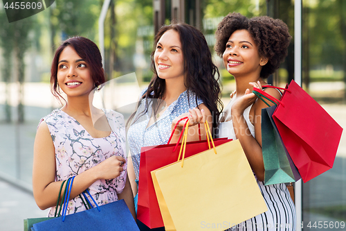 Image of happy women with shopping bags in city