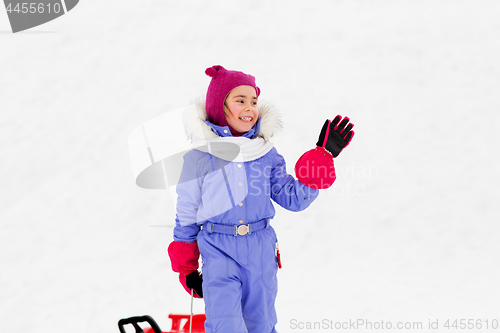 Image of happy little girl waving hand outdoor in winter