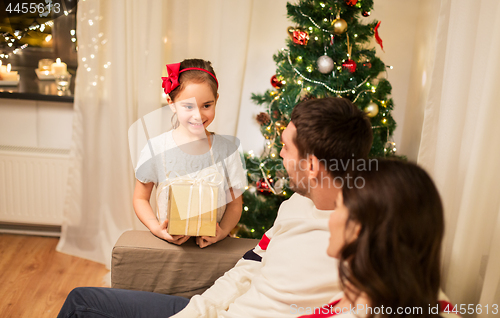 Image of happy family with christmas present at home