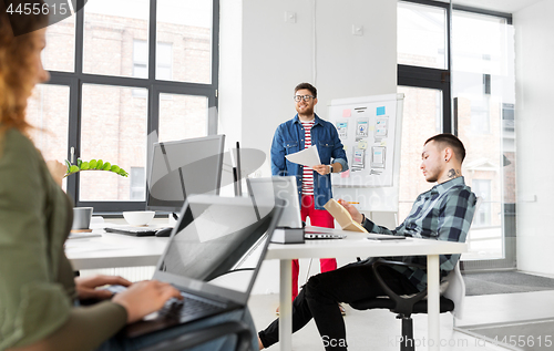 Image of creative man showing user interface at office