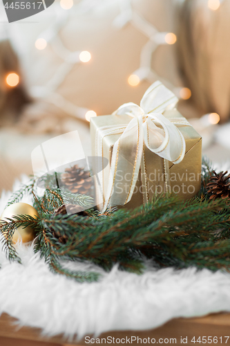 Image of christmas gift and fir wreath with cones and balls