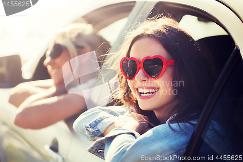 Image of happy teenage girls or women in car at seaside