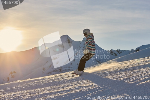 Image of Female snowboarder in sun flare