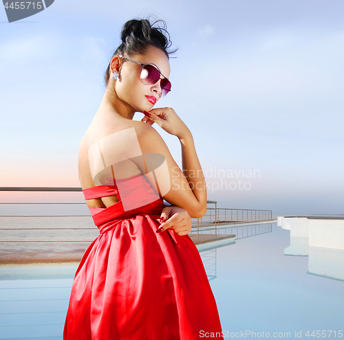 Image of brunette near the pool in expensive hotel