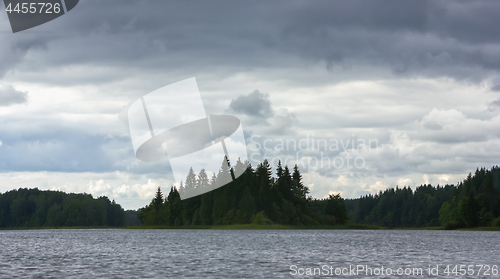 Image of Dynamic Cloudy Sky Over A Forest Lake