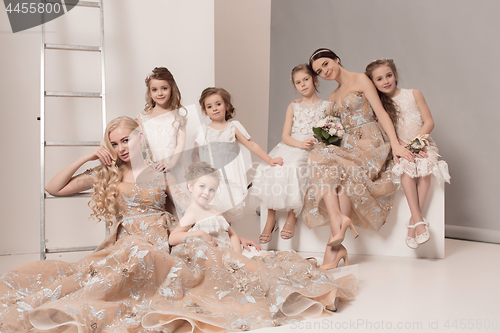 Image of Little pretty girls with flowers dressed in wedding dresses