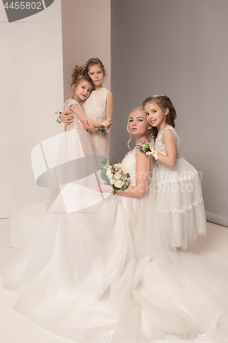 Image of Little pretty girls with flowers dressed in wedding dresses